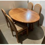 Light oak oval dining table and four chairs with light brown patterned fabric,