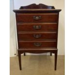 Mahogany four drawer music cabinet with fall front drawers, on tapered legs,