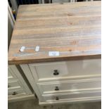 An off-white painted three drawer chest of drawers,