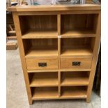 A light oak six drawer chest of drawers and eight compartments shelves,