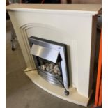A 240v fire with pebble effect set in a cream laminate fire surround,