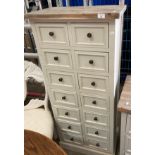 An off-white painted fourteen drawer storage cabinet,