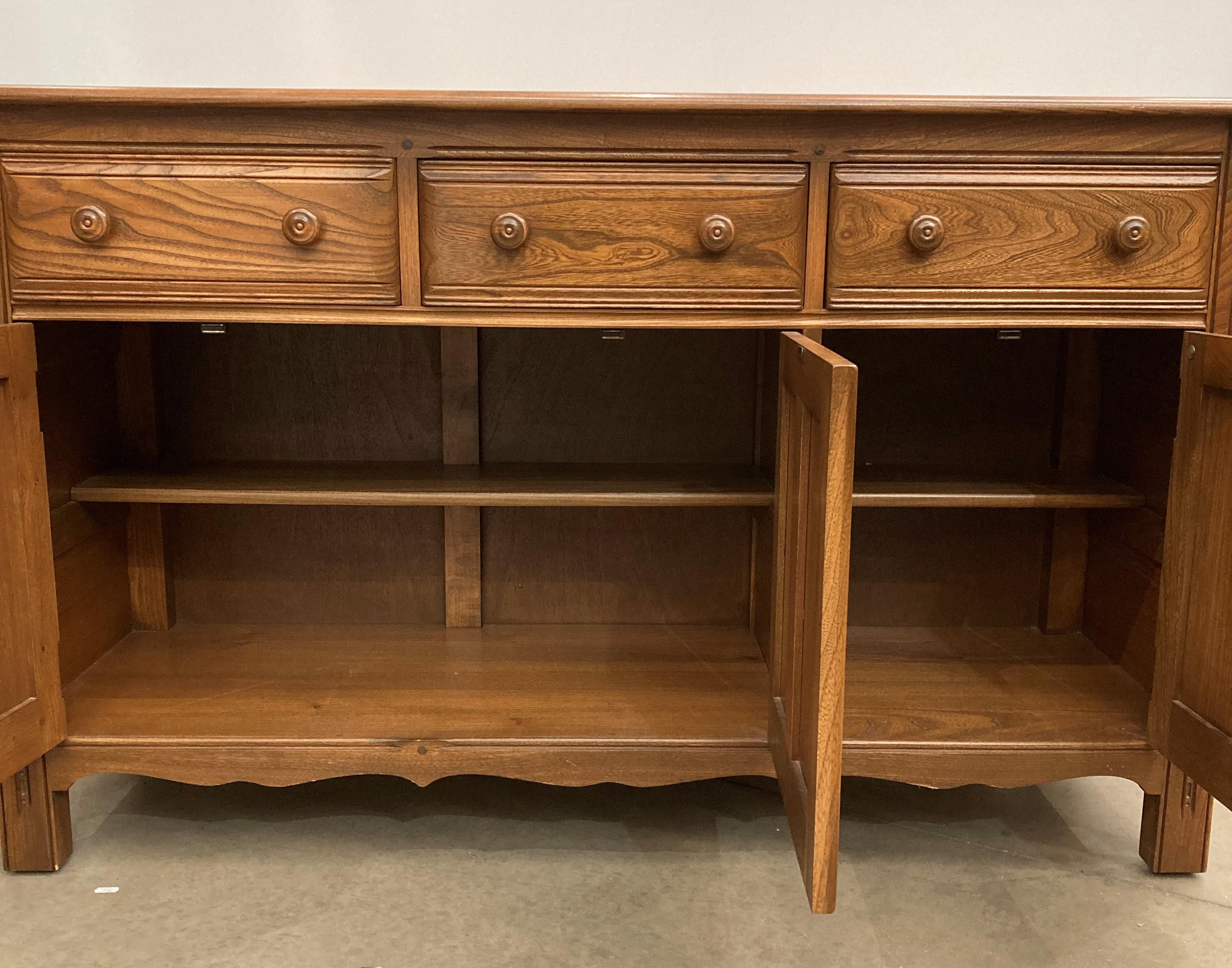 Ercol Lavenham dresser base, model 962D, with three drawers and three doors, in elm Golden Dawn, - Image 2 of 6