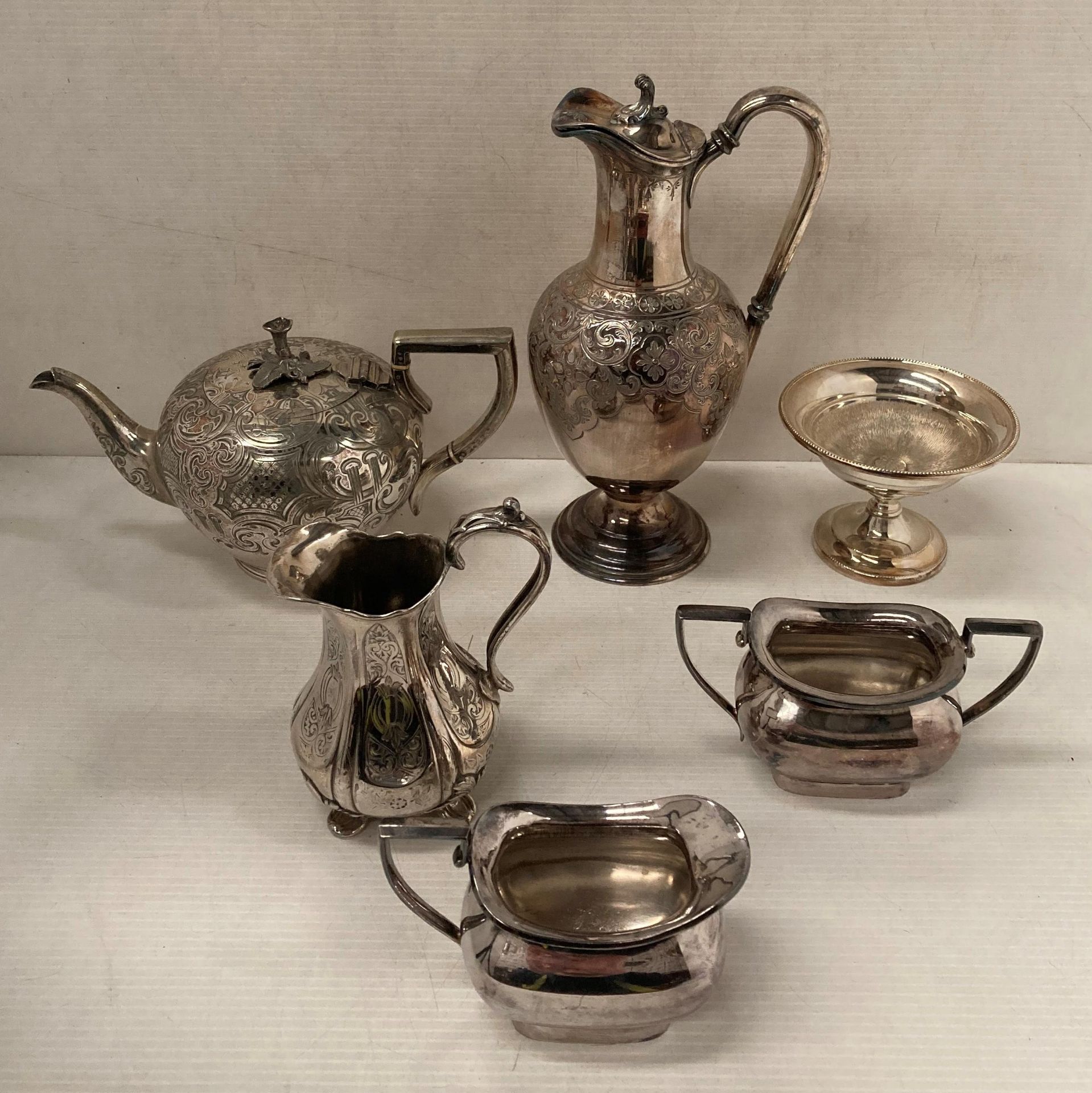 Six silver plated items including wine ewer, teapot, cream jug, bon bon dish, sugar bowl,