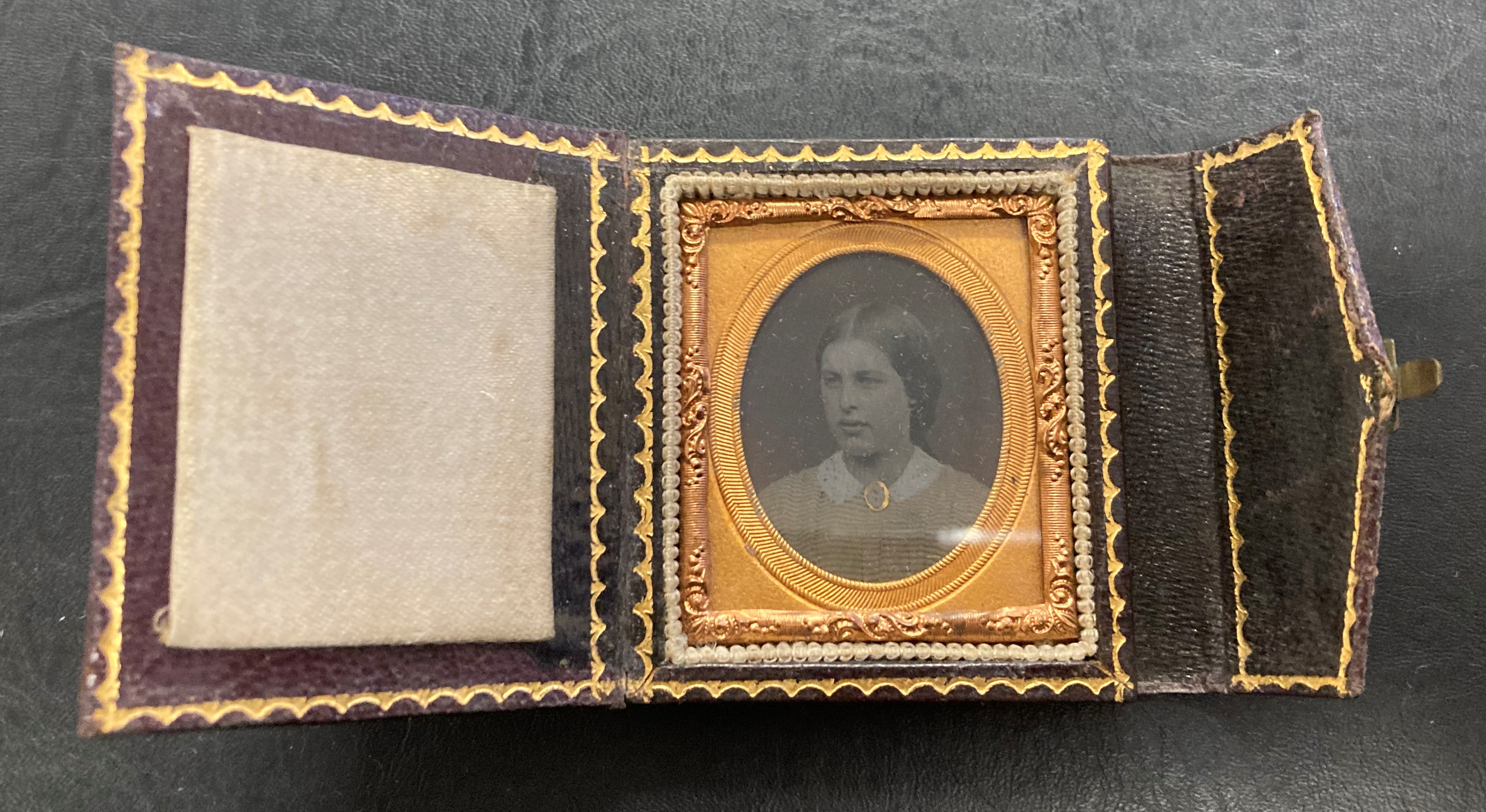 A leather bound fold out Antique Glass Ambrotype photograph in an ornate ormulu frame (dates back