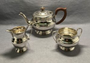 A silver three-piece tea service [hallmarked] (dated 1935, London) by W Greenwood & Sons.
