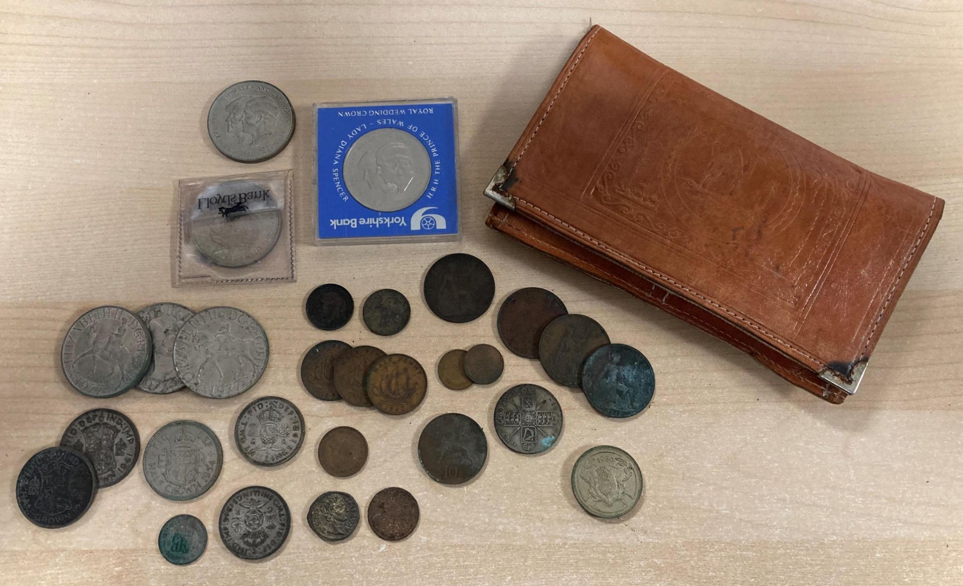 Contents to leather purse depicting a camel and palm tree-filled scene - a selection of coins and