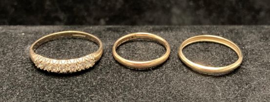 Three 9ct gold rings including two 9ct wedding bands (sizes M & J) and a 9ct gold band set with