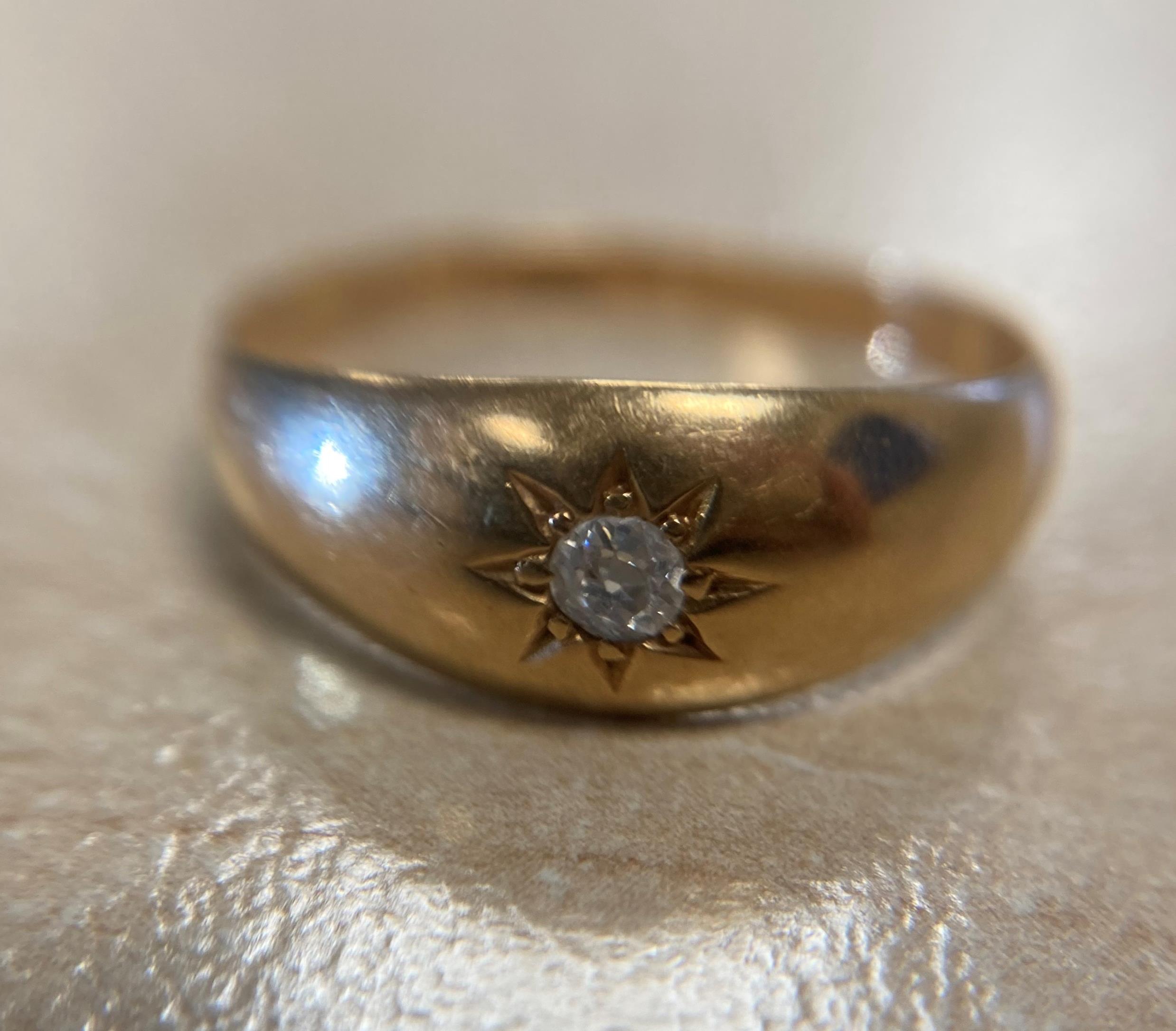 An antique 9ct yellow gold [stamped] ring with celestial engraving and faceted gypsy-set round-cut