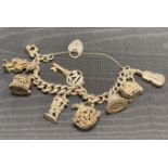Silver [hallmarked] charm bracelet approximately 16cm long with a heart-shaped padlock and nine