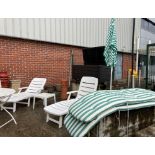 Two white plastic patio sun loungers both complete with green and white striped padded seats,