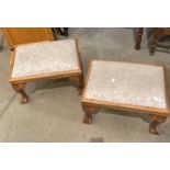 Two oak framed footstools on claw and ball feet with pink patterned upholstered seats (Saleroom