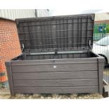 A brown plastic outdoor storage unit with lift top lid,