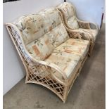 A cane two seater sofa and an armchair,