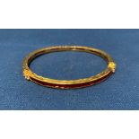 Gilt metal and ruby bangle with approximately sixty ruby stones, 7cm diameter,