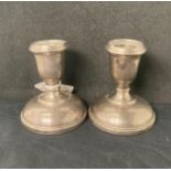 Pair of silver [hallmarked] short candlestick holders with weighted bases, 9cm high,