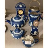 Seven pieces of blue and white Wedgwood pottery including a mantel clock, ice bucket, sugar shaker,
