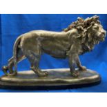 Figurine of a lion (possibly bronze) on black marble base by Padrino, 50cm long,