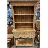 Pine farmhouse-style kitchen side unit with two shelves over a five-drawer bottom section with an