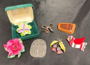 An assortment of vintage brooches including two porcelain/bone china floral brooches (rose one has