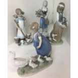 Four figurines including three Lladro - two x girls with kittens and girl with geese 19cm high
