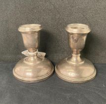 Pair of silver [hallmarked] short candlestick holders with weighted bases, 9cm high,