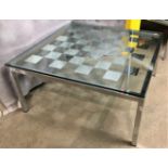 A square chrome-framed glass-topped chequer board coffee table 70cm square x 15cm high (saleroom