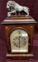 A mahogany with line inlay mantel clock with metal lion and ball top - 47cm high (saleroom