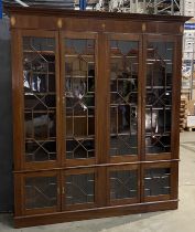 A substantial mahogany wall unit with four astragal glazed doors over matching four short door base