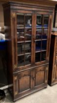 A Titchmarsh and Goodwin solid oak bookcase with two upper oak lined glazed doors over two door