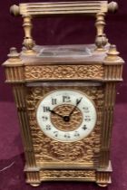 A small ornate brass carriage clock 17cm high to top of handle,