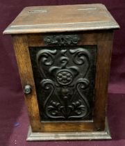 An oak tobacco cabinet with Art Nouveau metal plaque to front internally fitted to take pipes with