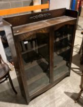 A 1930s oak bookcase with twin glazed doors,