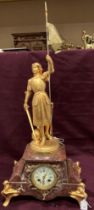 A Joan of Arc figural mantel clock in brown marble and gilt finish,