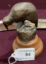 A small bronze model of a Kiwi on wood base 9cm high and a boomerang (saleroom location: S3GC02)