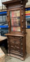 A Victorian heavily carved wall unit with upper glazed door with two shelves,