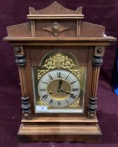 A wood cased mantel clock with ormolu and metal face - 43cm high complete with key (saleroom