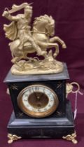A black slate and gilt finish mantel clock surmounted with a knight on horseback - 42cm high
