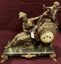 A metal figural mantel clock with a lady playing a flute,