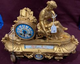A gilt finish figural mantel clock surmounted by a lady with pipes,