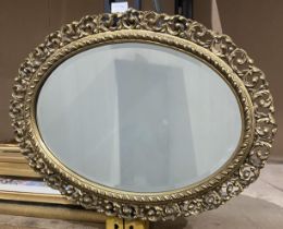 A gilt-framed oval wall mirror,