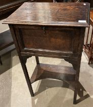 An oak cabinet with hinged top and fall front on square supports with an undershelf 50 x 36 x 83cm