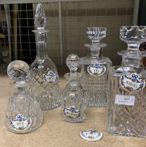 Five various decanters with six Crown Staffordshire Fine Bone China spirit labels - Whisky, Gin,