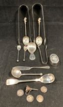 Fourteen assorted silver hallmarked items including three assorted sugar tongs, seven spoons,