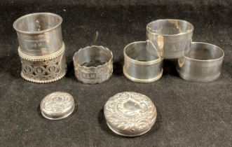 Six assorted silver hallmarked napkin rings and two assorted silver hallmarked bottle tops.