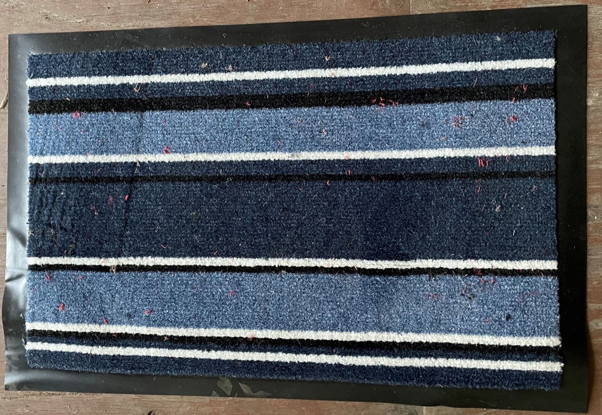 Contents to half pallet - approximately 450 blue striped rubber backed door mats approx.