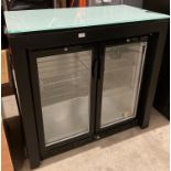 Two-door glass-front bottle chiller with glass-topped black wooden surround (saleroom location:
