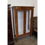 A late 19th Century French inlaid walnut display cabinet with two doors and standing on square