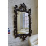 A large Rococo style carved wooden wall mirror, approx.