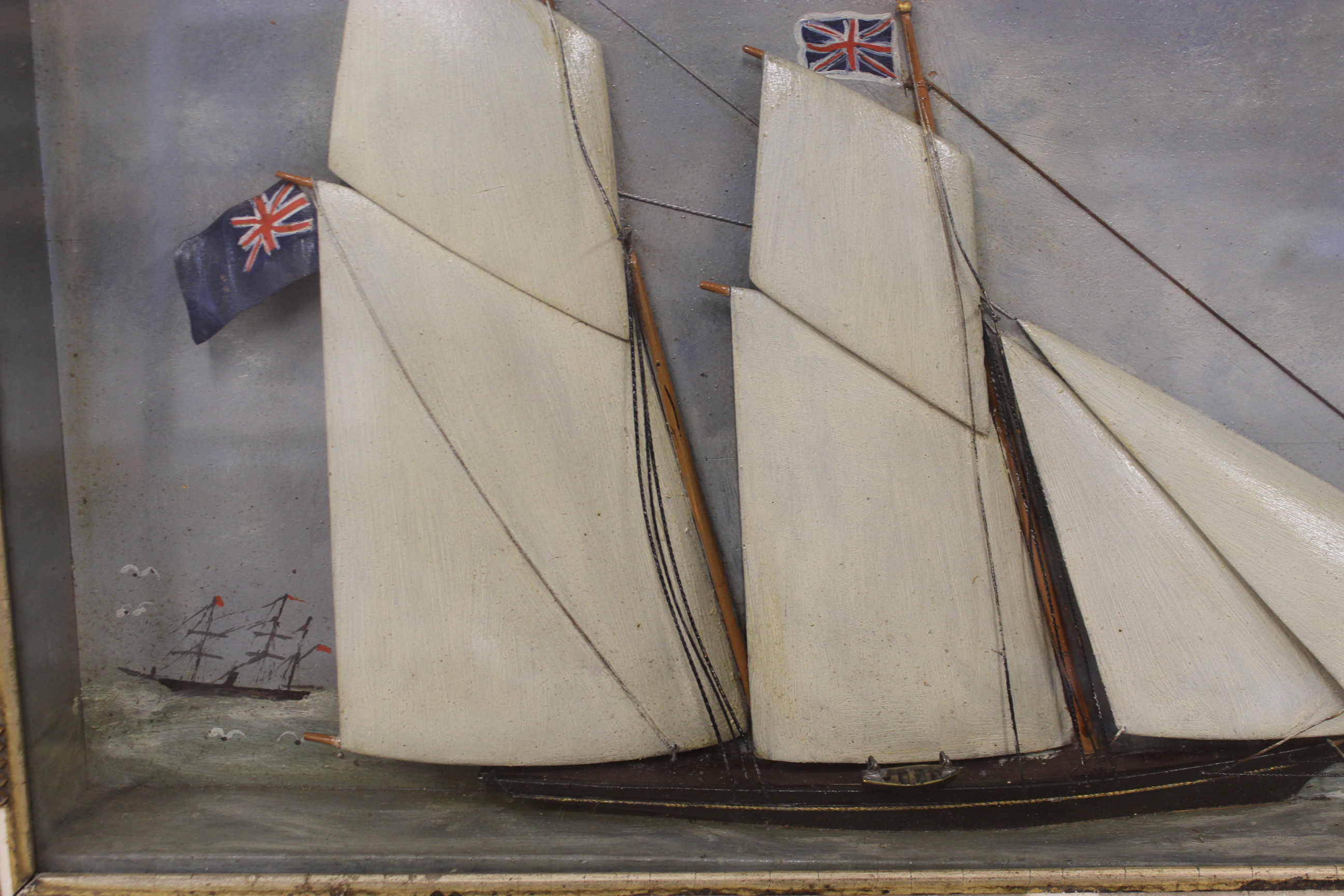 A 19th Century framed and glazed painted wooden half model of a ship in full sail against a painted - Image 2 of 3